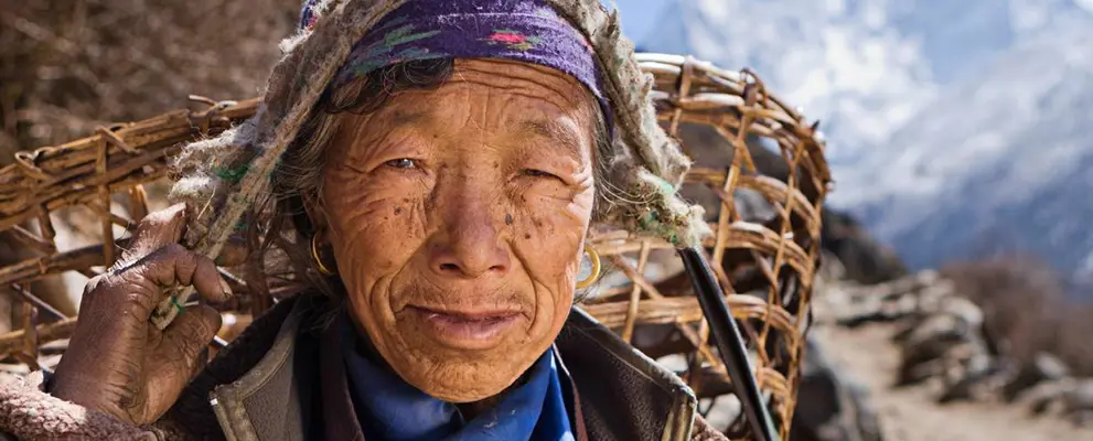 Nepalese woman carrying basket in mountains